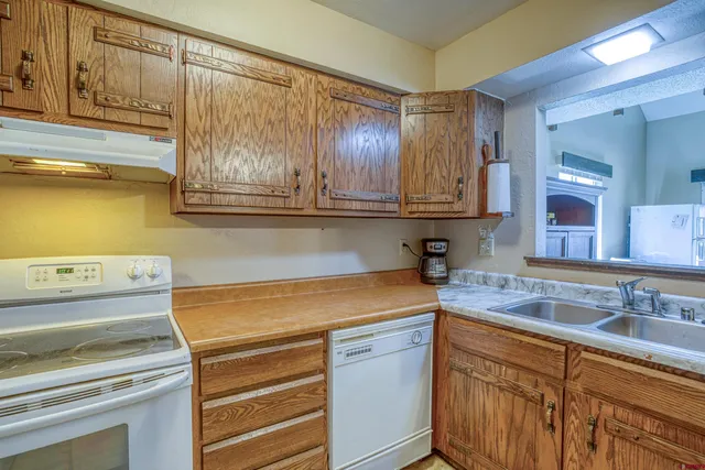 a kitchen with granite countertop cabinets stainless steel appliances and a sink