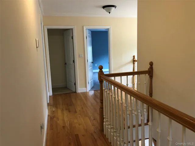a view of a hallway with wooden floor and stairs