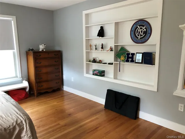 a bedroom with a bed and a closet with wooden floor