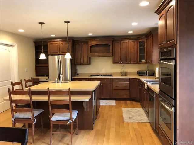 a kitchen with stainless steel appliances kitchen island granite countertop a sink and cabinets