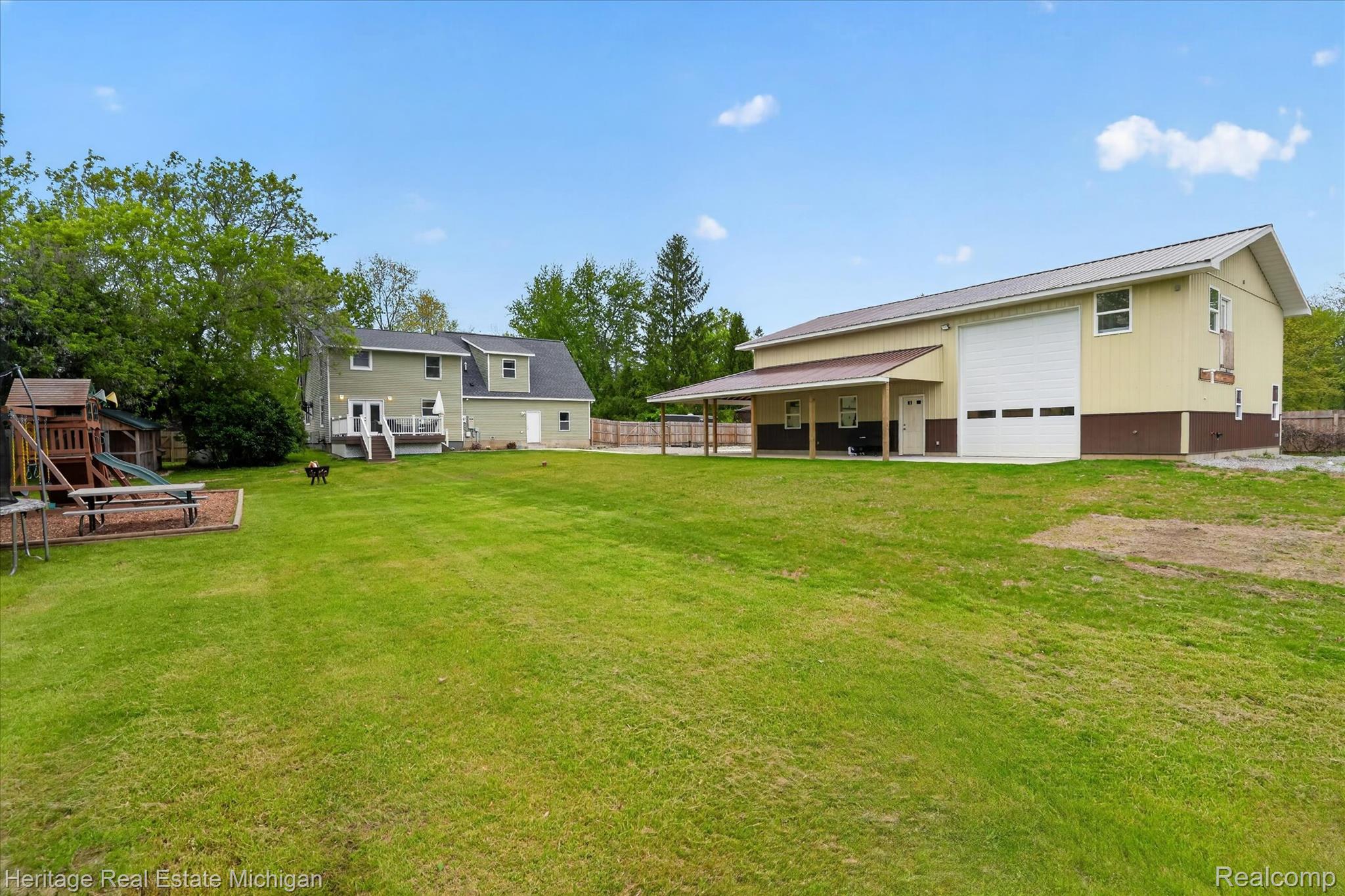 5835 Warner Road Fowlerville, MI 48836 - Photo 3 of 59 Rear view of property with a garage and a playground