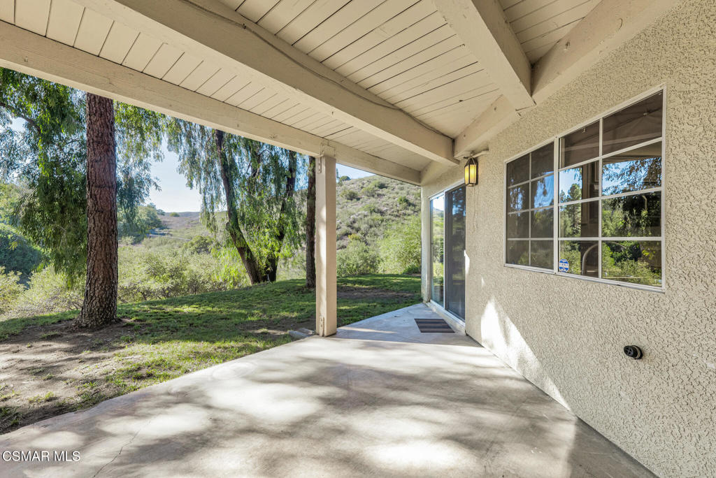 a view of a porch with a floor to ceiling window and yard