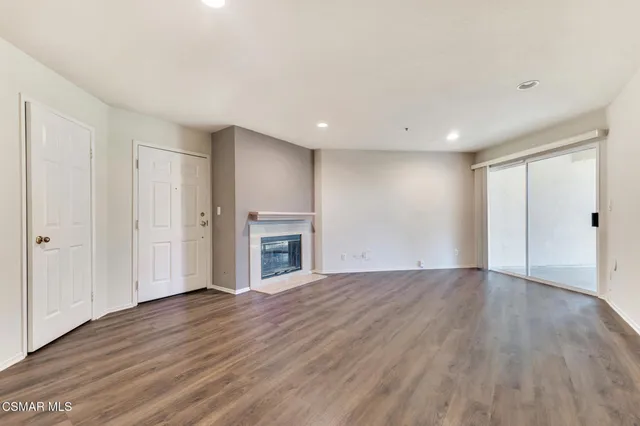 a view of empty room with wooden floor and fireplace