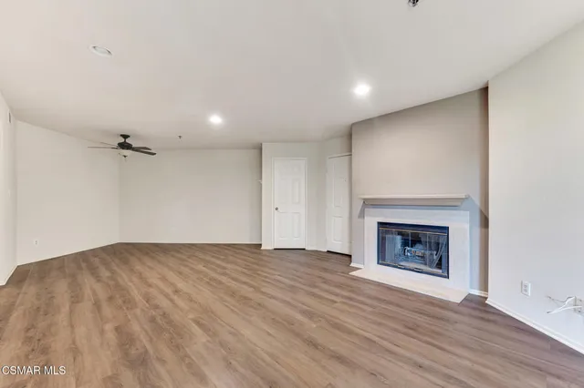 an empty room with wooden floor and fireplace
