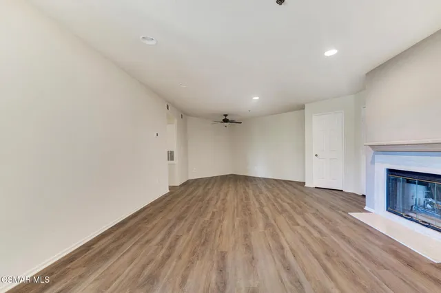 a view of empty room with wooden floor and fireplace