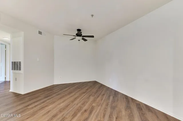 a view of empty room with wooden floor