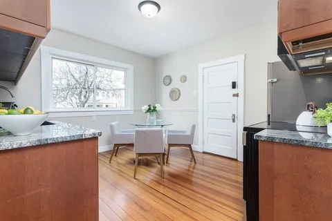 a dining room with wooden floor and a window