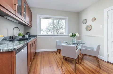 a dining room with furniture a rug and wooden floor