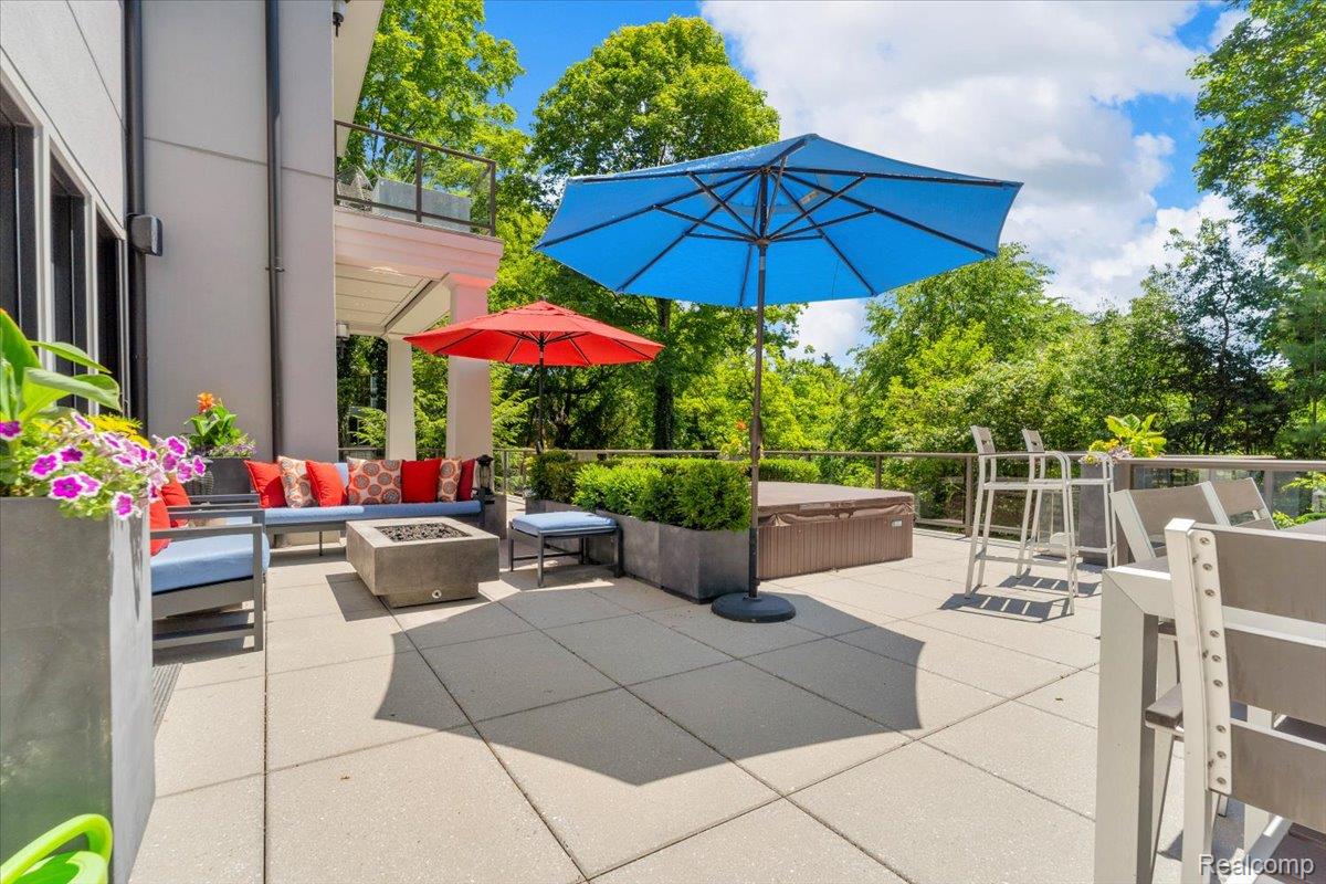 195 Baldwin Road Birmingham, MI 48009 - Photo 59 of 76 Spacious outdoor patio featuring large-format paver tiles, a built-in fire pit, and a privacy wall