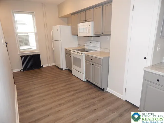 a kitchen with white cabinets and white appliances