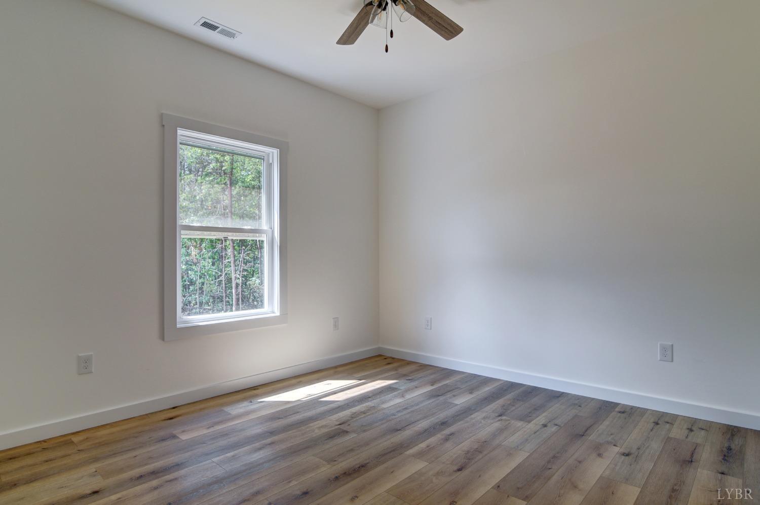 330 Bellview Road Appomattox, VA 24522 - Photo 20 of 26 an empty room with wooden floor chandelier fan and windows