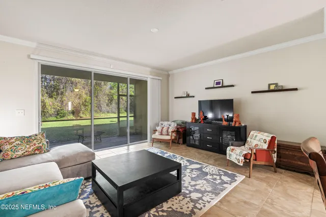 a living room with furniture and a floor to ceiling window