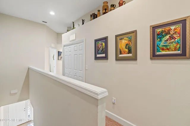 a view of hallway with wall paintings and a window