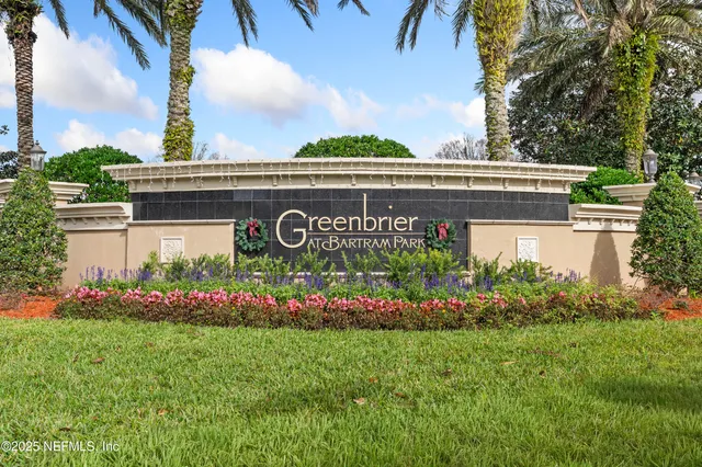 a view of sign board with flower plants