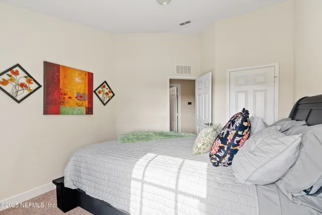 a bedroom with bed and painting on the wall