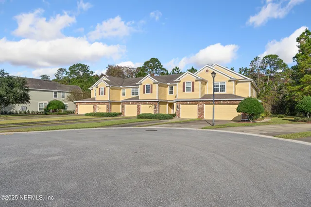 a front view of a house with a yard and potted plants