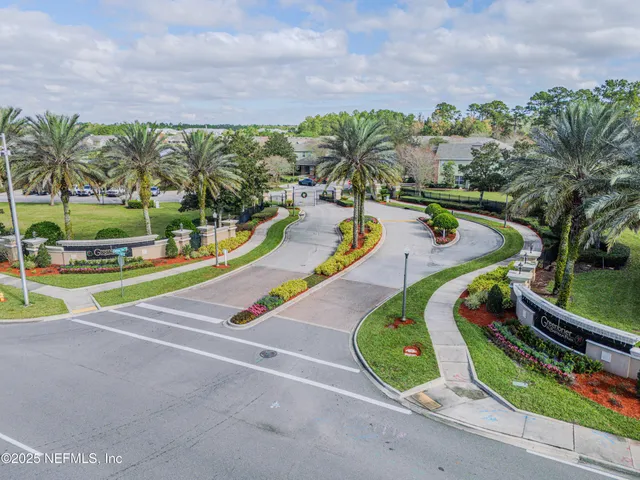 an aerial view of a swimming pool with a yard and palm trees