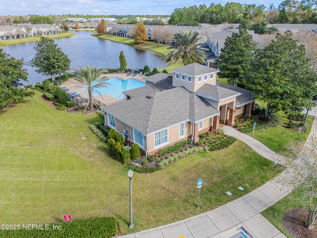 an aerial view of a house with a garden and lake view