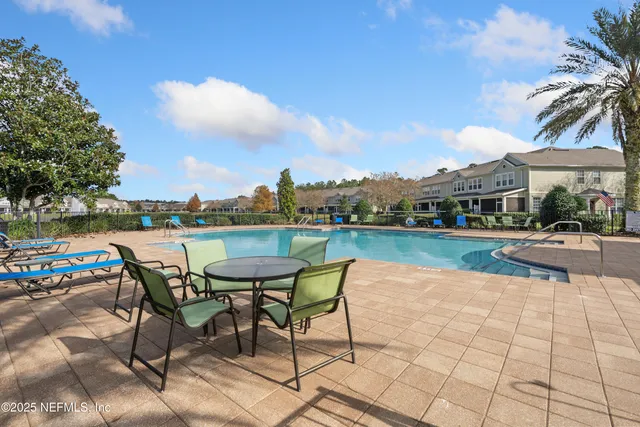 a swimming pool with outdoor seating and lake view