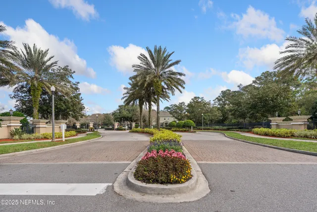 a view of a swimming pool with a yard and palm trees
