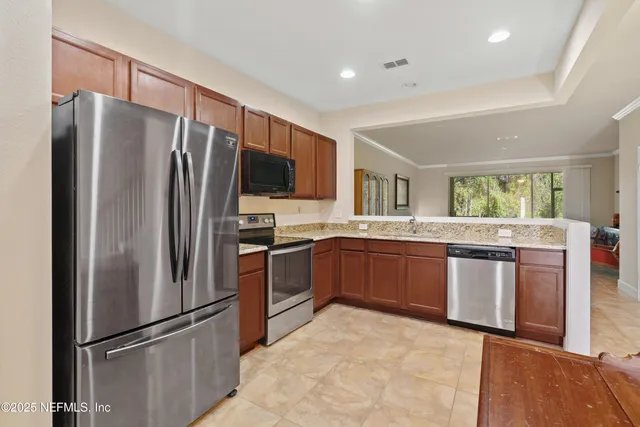 a kitchen with stainless steel appliances granite countertop a refrigerator stove and sink