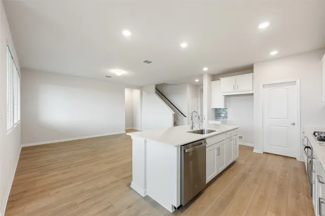 a kitchen with white cabinets and appliances