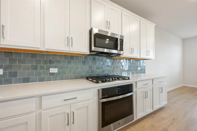a kitchen with stainless steel appliances granite countertop a sink stove and microwave