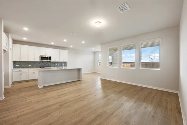 a view of kitchen with kitchen island wooden floor and center island