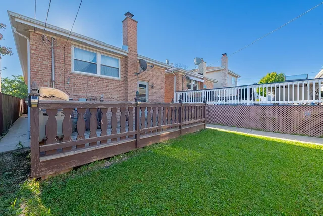 a view of a house with wooden deck and yard