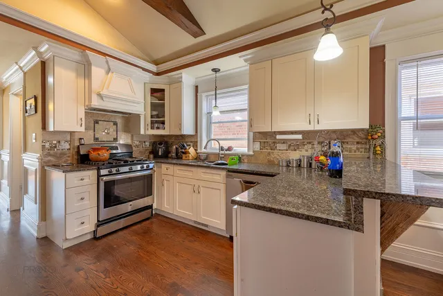 a kitchen with stainless steel appliances granite countertop a stove a sink and a refrigerator