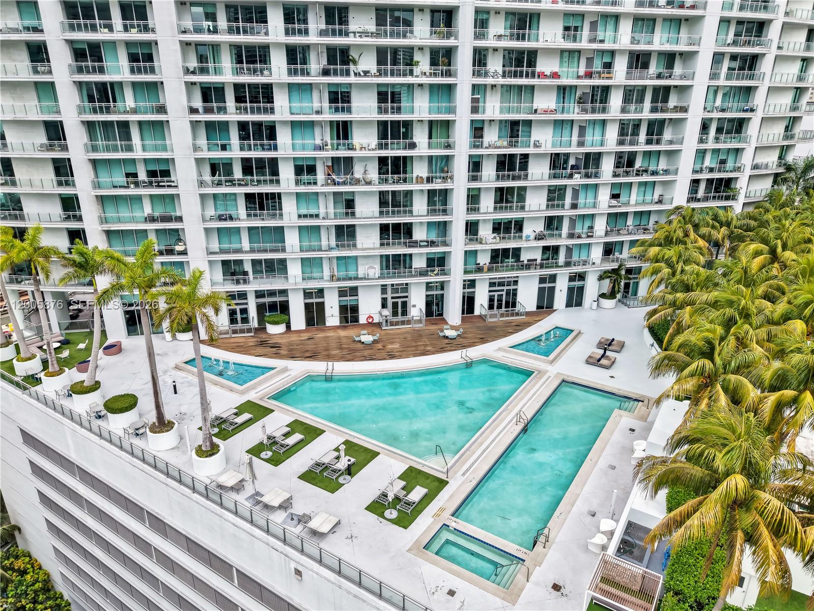 90 Southwest 3rd Street, Unit TH 308 Miami, FL 33130 - Photo 22 of 28 a view of a swimming pool with a lounge chairs