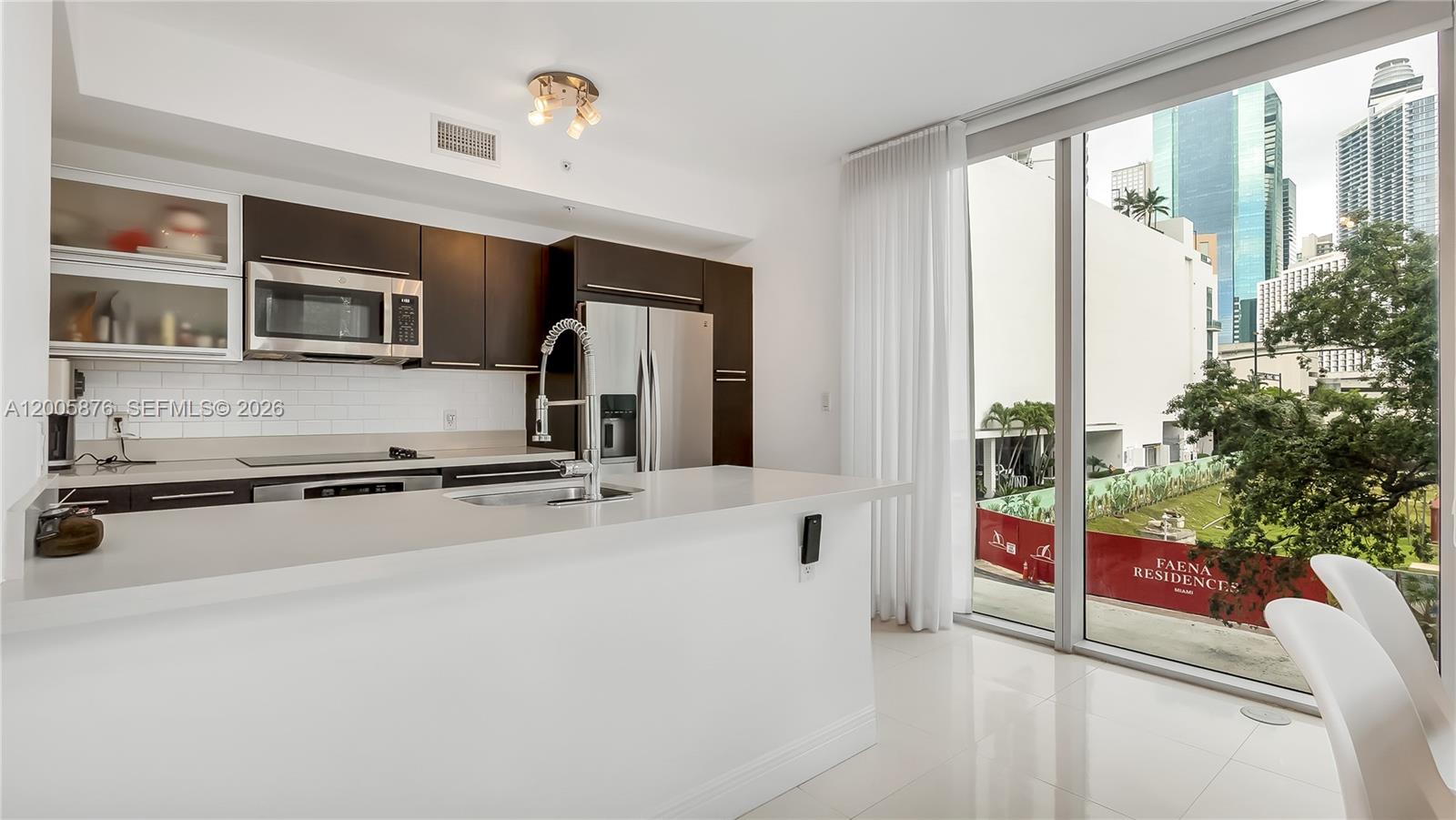 90 Southwest 3rd Street, Unit TH 308 Miami, FL 33130 - Photo 9 of 28 a kitchen with stainless steel appliances a stove top oven a sink and a refrigerator