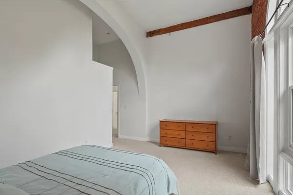 a bedroom with a bed and a wall painting