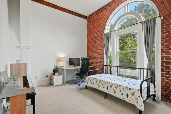 a bedroom with a bed a window and chair