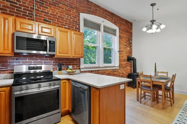 a kitchen with stainless steel appliances a stove a sink and a microwave