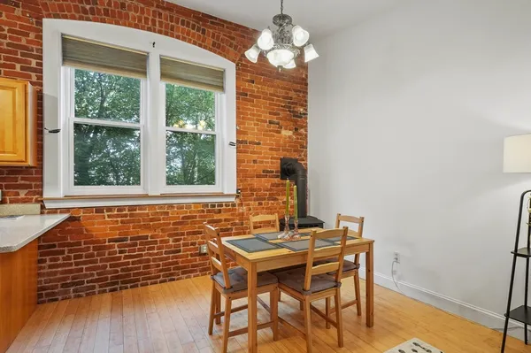a dining room with chandelier and wooden floor