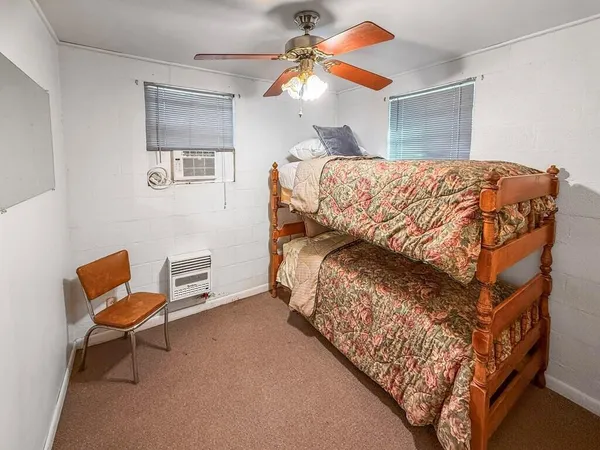 a bedroom with a bed and a chandelier fan