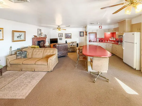 a living room with furniture and a refrigerator