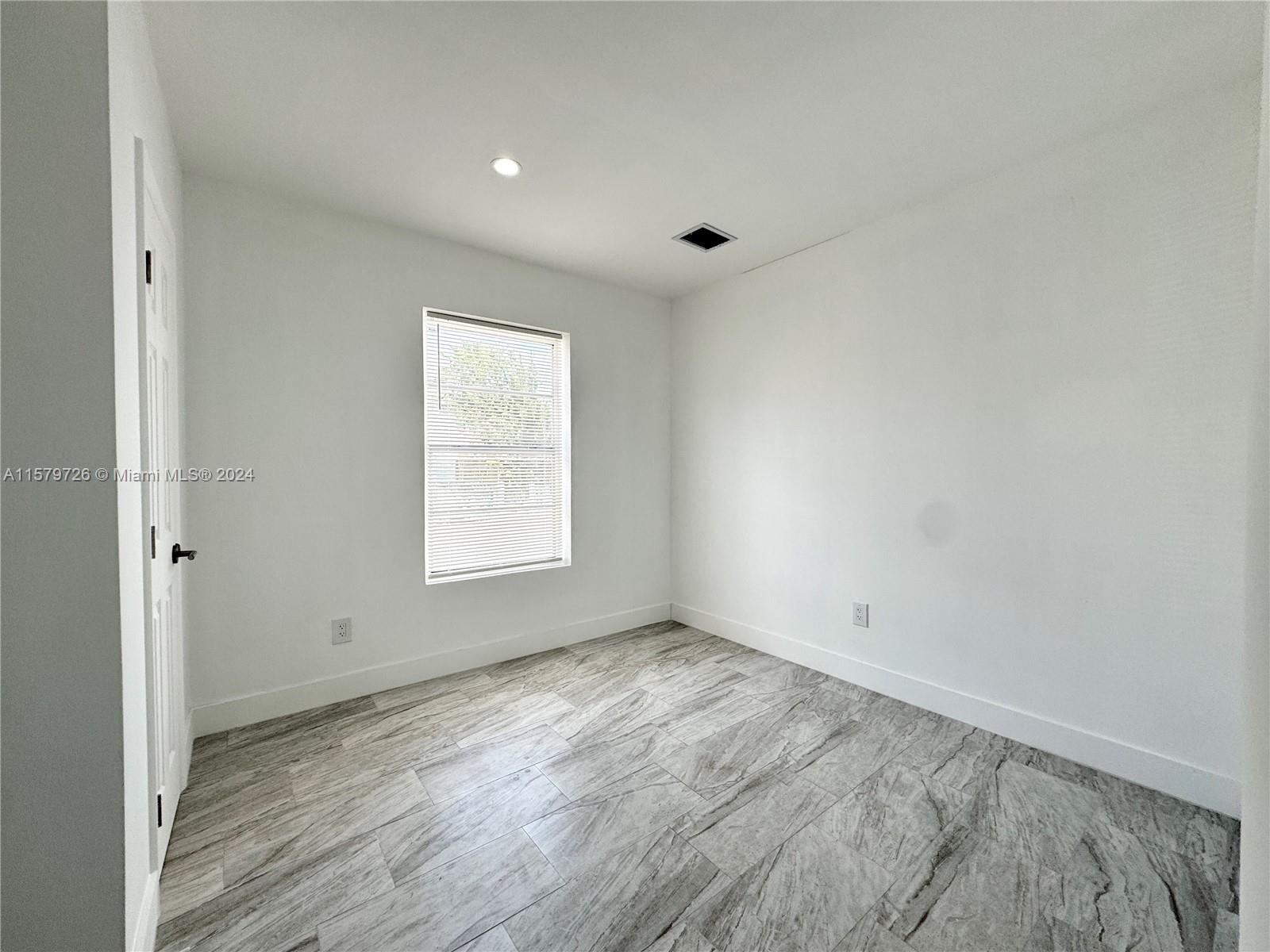 6955 Rue Vendome, Unit 2 Miami Beach, FL 33141 - Photo 12 of 21 wooden floor in an empty room with a window
