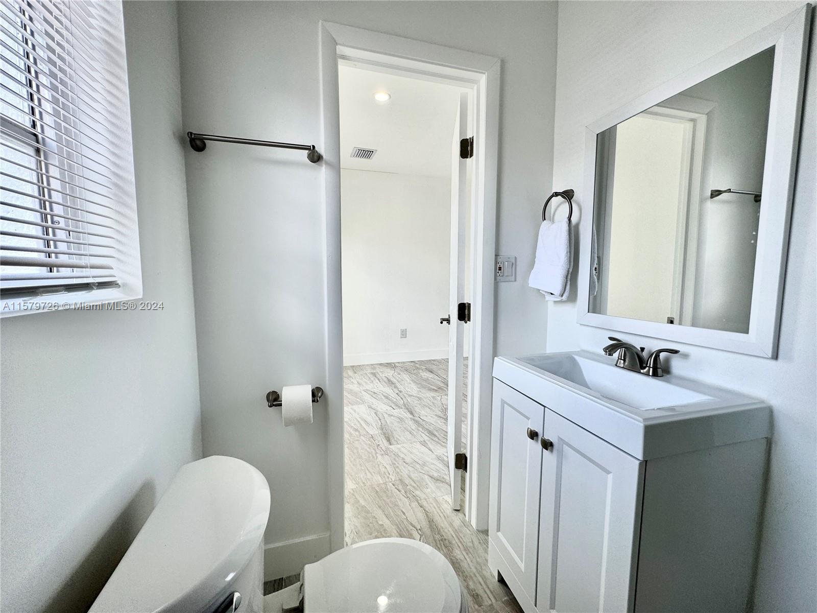 6955 Rue Vendome, Unit 2 Miami Beach, FL 33141 - Photo 16 of 21 a bathroom with a granite countertop sink toilet and shower