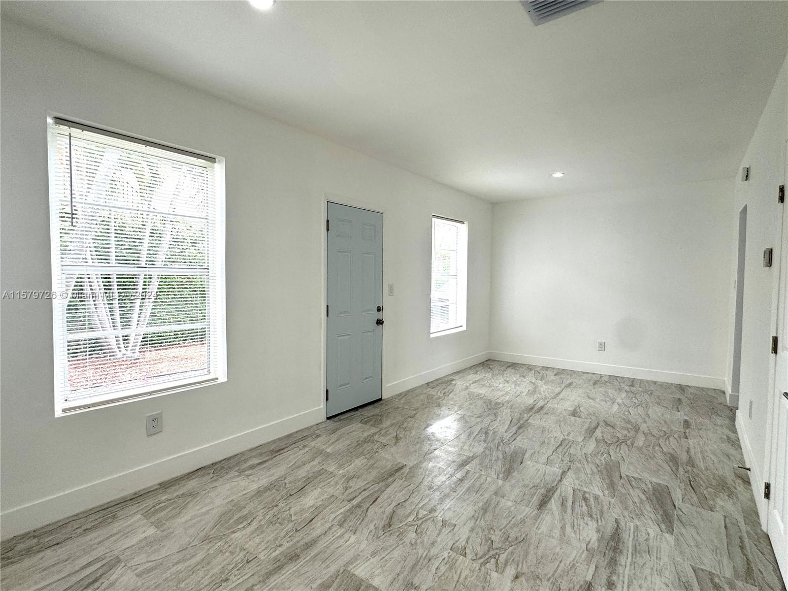 6955 Rue Vendome, Unit 2 Miami Beach, FL 33141 - Photo 4 of 21 a view of an empty room with wooden floor and a window