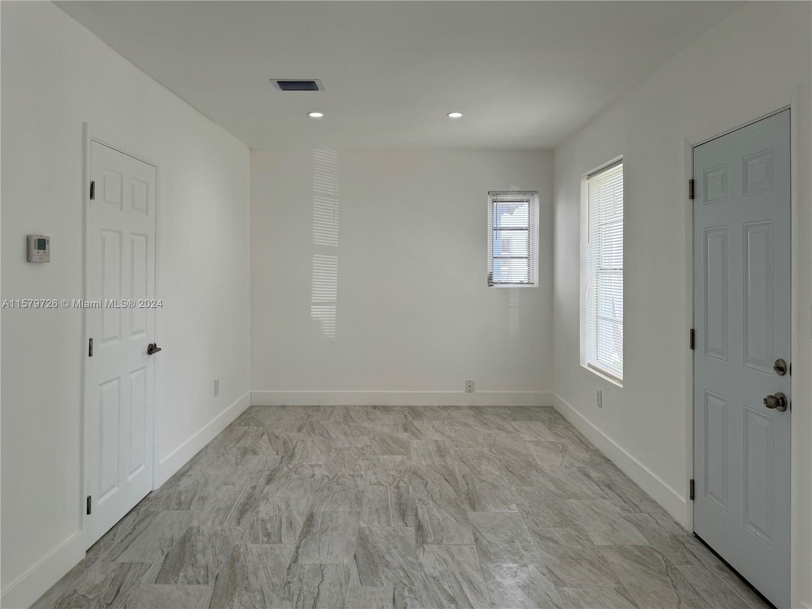 6955 Rue Vendome, Unit 2 Miami Beach, FL 33141 - Photo 7 of 21 a view of an empty room with wooden floor and a window