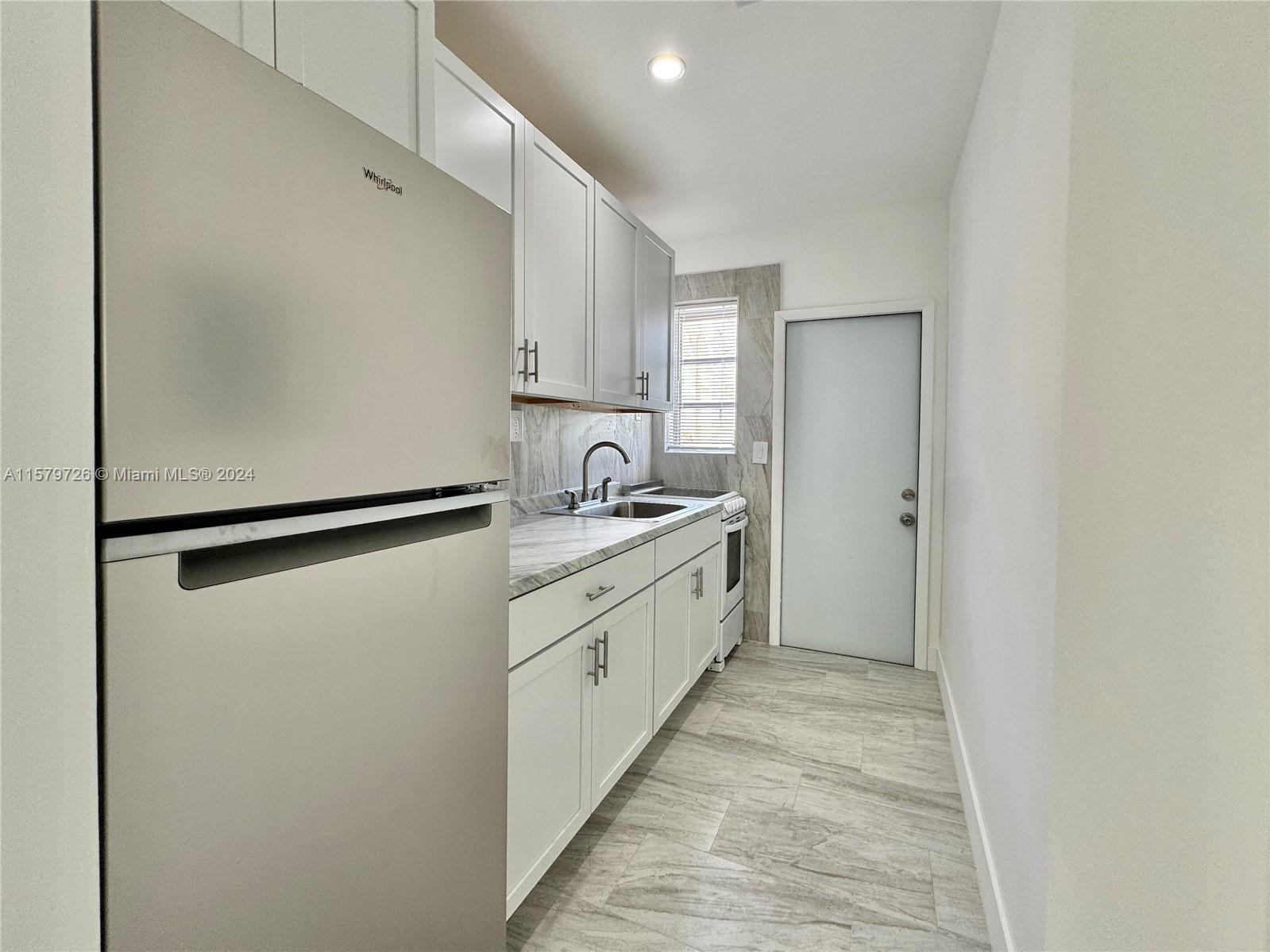 6955 Rue Vendome, Unit 2 Miami Beach, FL 33141 - Photo 10 of 21 a large white kitchen with a sink and refrigerator