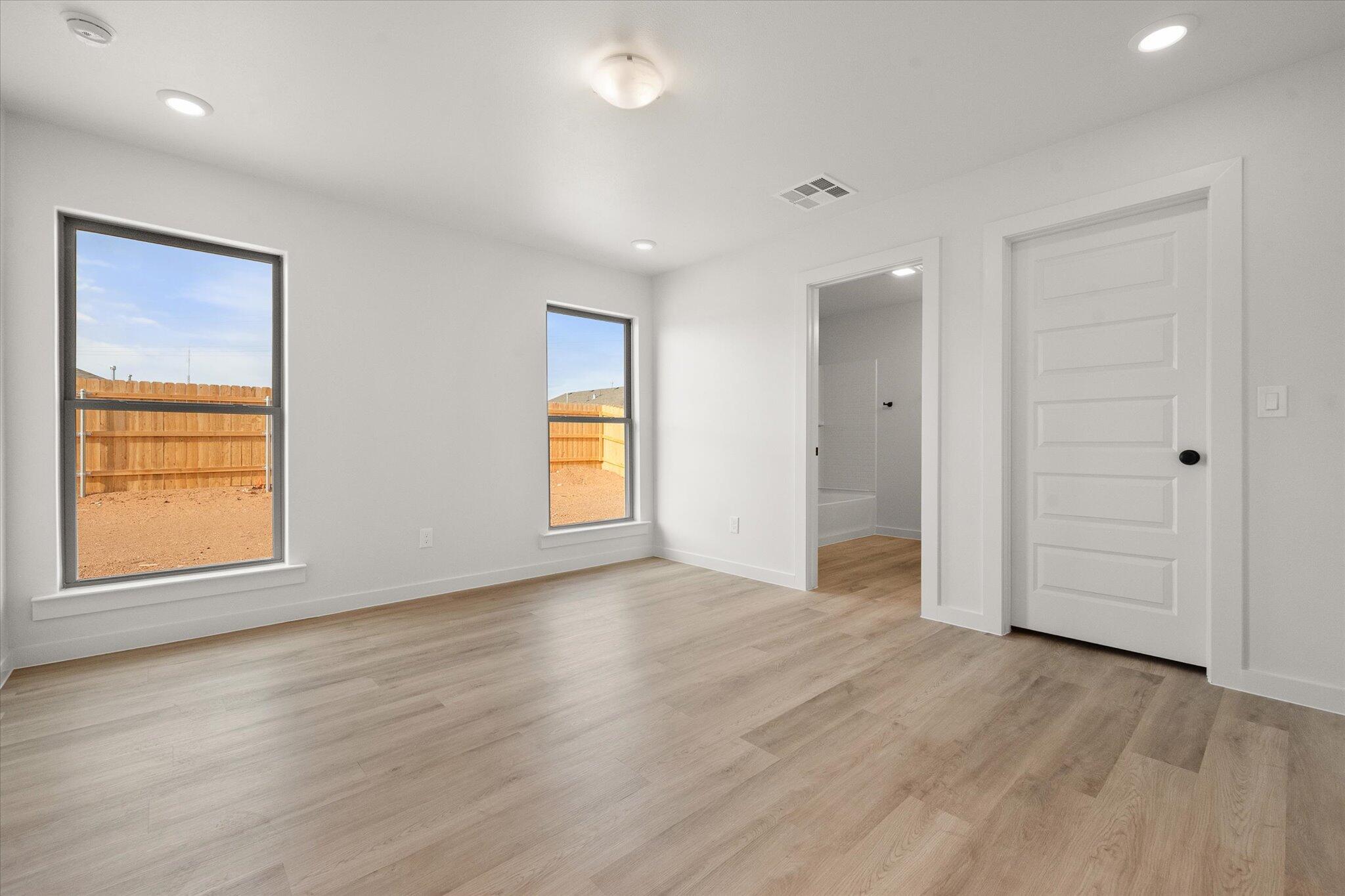 6308 Virginia Avenue Lubbock, TX 79407 - Photo 11 of 20 an empty room with wooden floor and windows