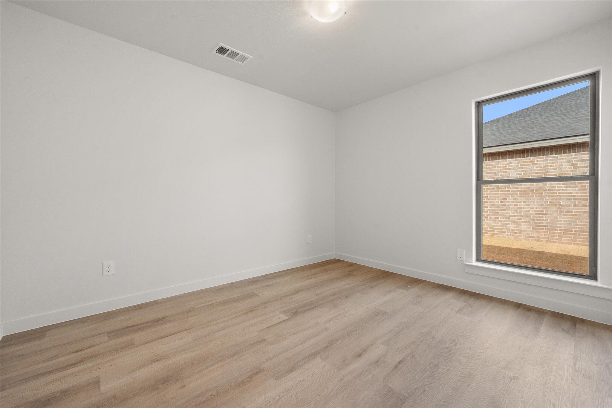 6308 Virginia Avenue Lubbock, TX 79407 - Photo 15 of 20 a view of an empty room with wooden floor and a window