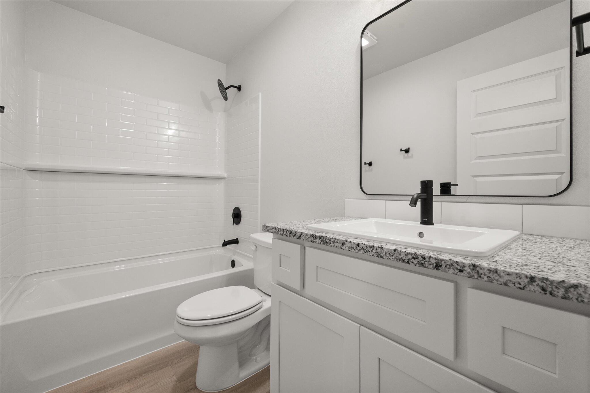 6308 Virginia Avenue Lubbock, TX 79407 - Photo 16 of 20 a bathroom with a granite countertop sink toilet and shower