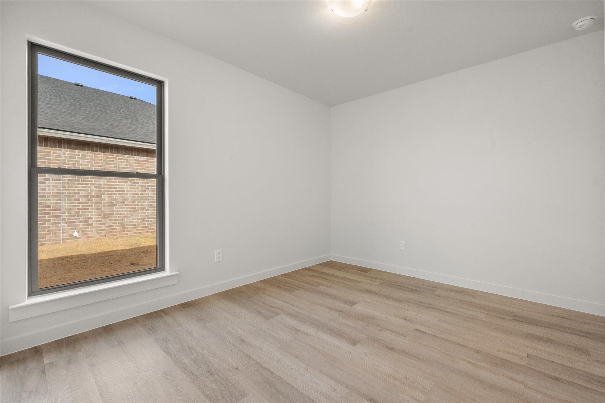 6308 Virginia Avenue Lubbock, TX 79407 - Photo 17 of 20 a view of an empty room with wooden floor and a window
