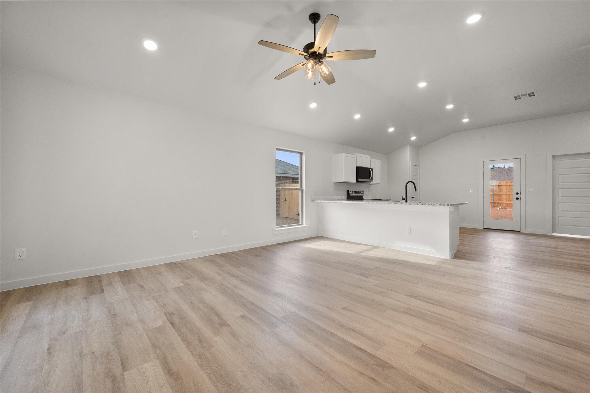 6308 Virginia Avenue Lubbock, TX 79407 - Photo 3 of 20 a view of a big room with wooden floor and windows