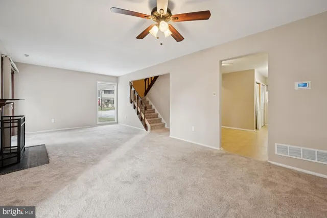 a view of a livingroom with a ceiling fan and window