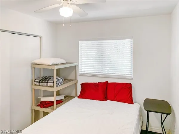 a bedroom with a bed a dresser and a chandelier